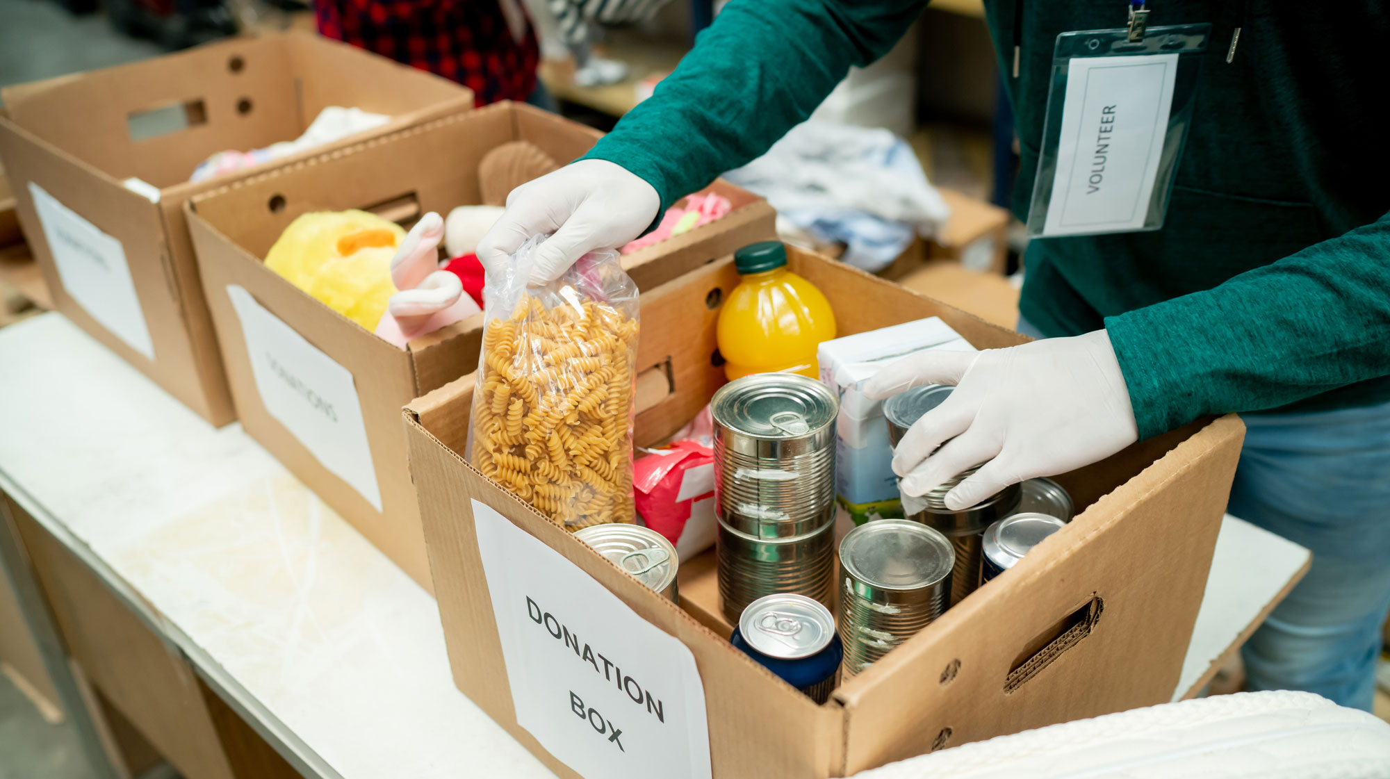 Volunteers load food donations into a box